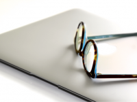 closed laptop with glasses on top