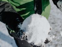 gloved hand holding a snowball