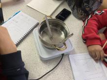 metal pot on hotplate heating water with thermometer