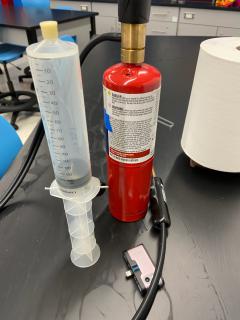 large syringe and handheld red oxygen tank