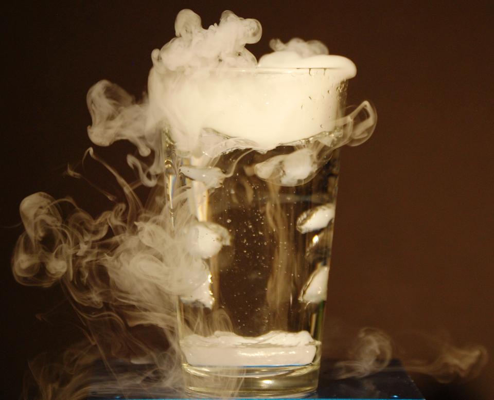 dry ice sublimating in water in a clear drinking glass