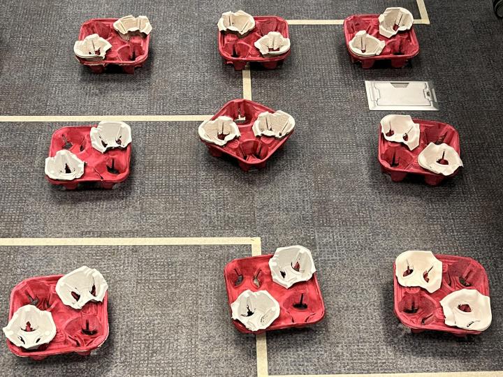 An ordered array of cup holder water molecule models used to represent a crystal structure 