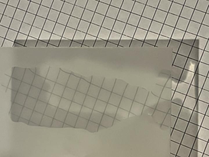 A layer of water on a sheet of etched glass makes it more transparent to see the pattern under the glass