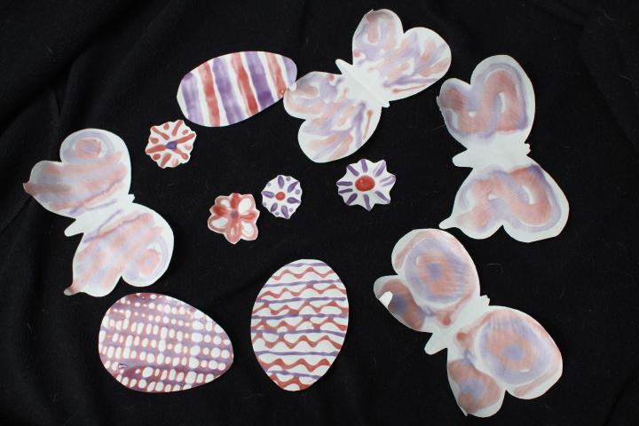 Photochromic glue applied to paper flowers, eggs and butterflies and viewed in outdoor light