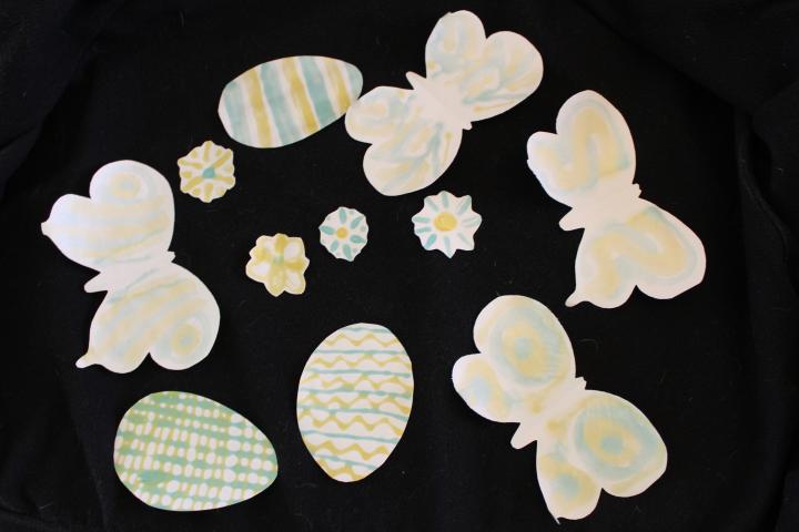 Photochromic glue applied to paper flowers, eggs and butterflies and viewed in indoor light