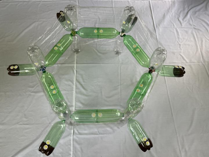 Plastic bottle orbital model of benzene using the trigonal pyramidal bottle cap clusters and plastic wrap to represent delocalized pi bonds