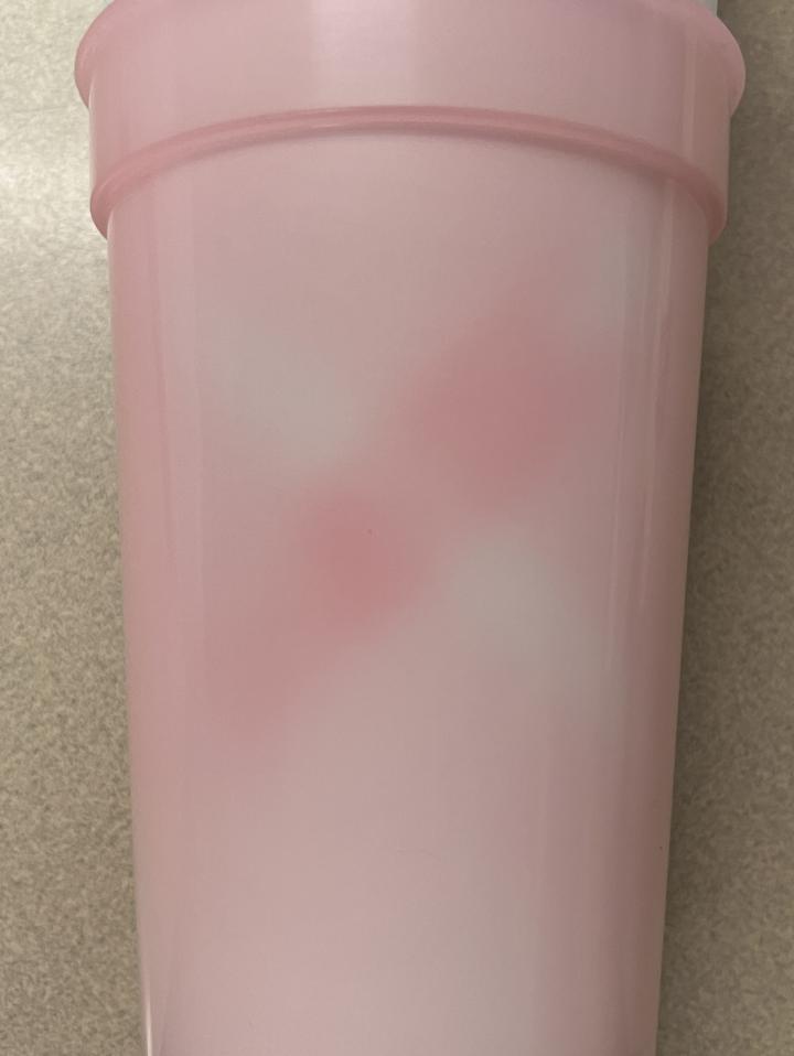 Thermochromic plastic cup with regions that have been decolorized by warming in contact with a stretched deflated latex balloon and regions that have been darkened by cooling in contact with a contracted balloon 