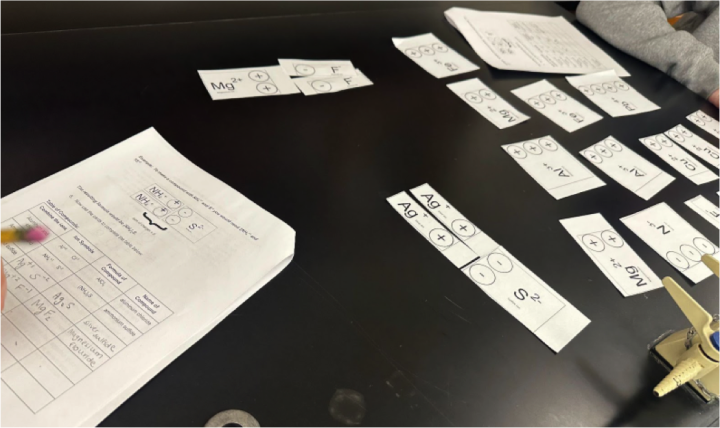 students move puzzle pieces and complete worksheet on black counter top