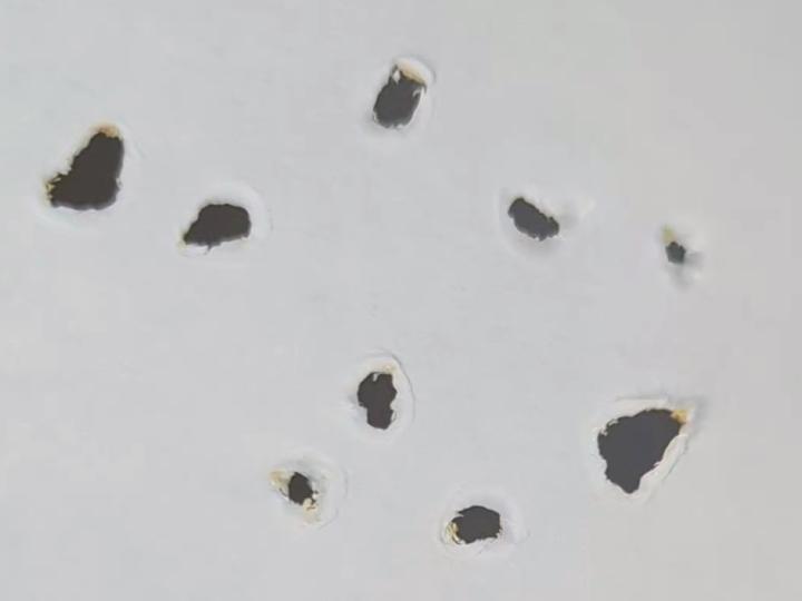 holes created in paper by smashing steel ball bearings