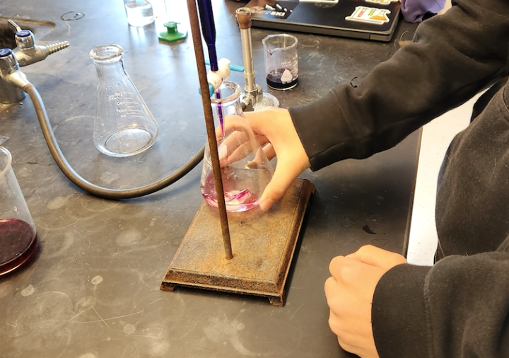 students testing sample using titration in chemistry lab