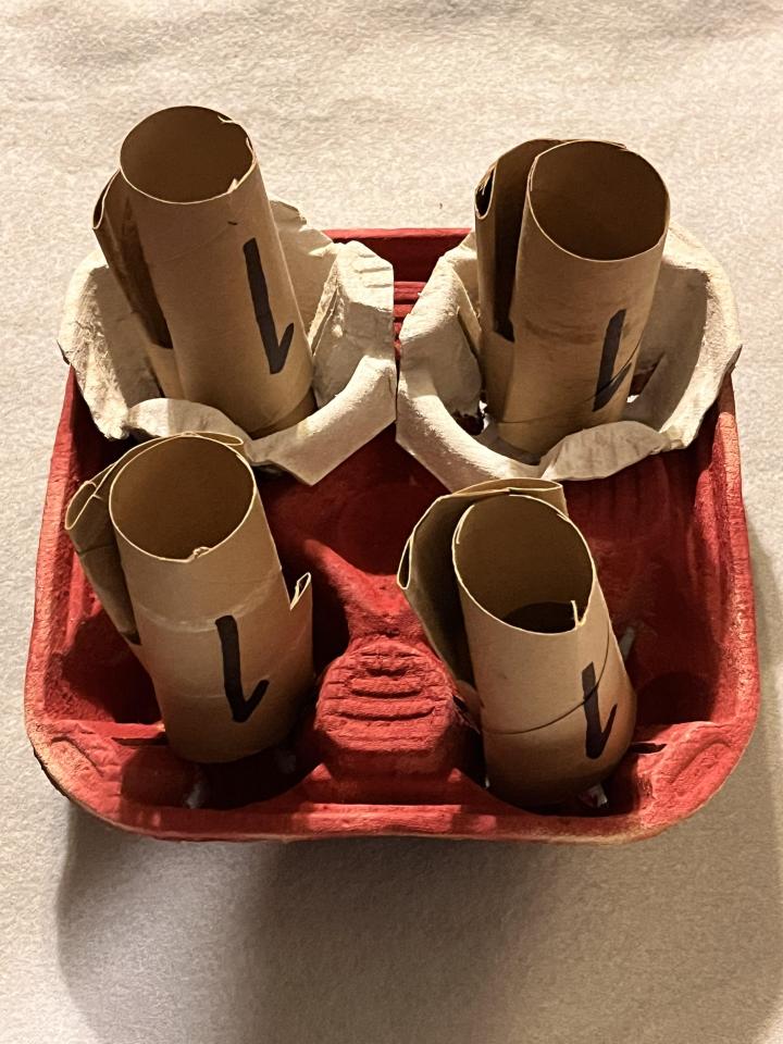 Cup holder arrangements featuring electrons represented by a variety of items