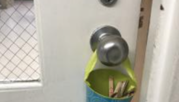 can of popsicle sticks hanging on classroom doorknob
