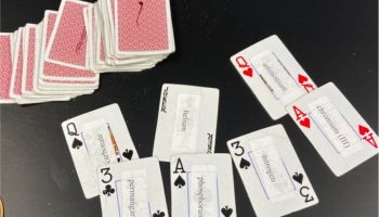 red deck of cards with some turned over and showing stickers with names of elements and ions on the face of the cards