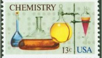 chemistry themed stamp 4 pieces of glassware holding colored solutions and a ring stand 