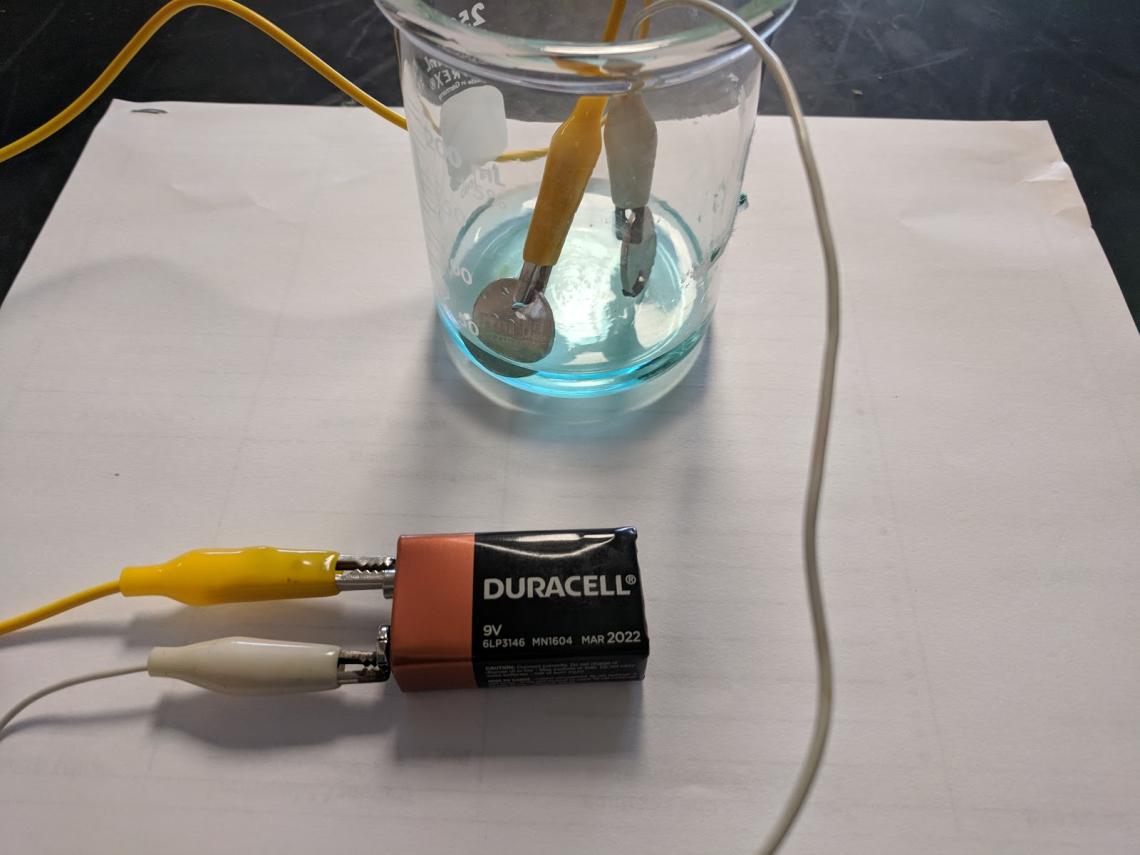 electroplating using a beaker, blue solution, copper electrode, 9V battery and alligator clips