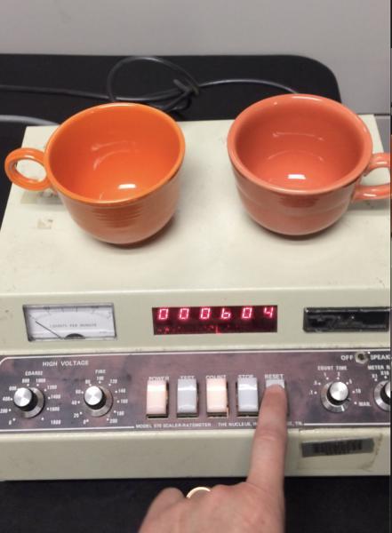 two orange fiesta ware cups on Geiger counter