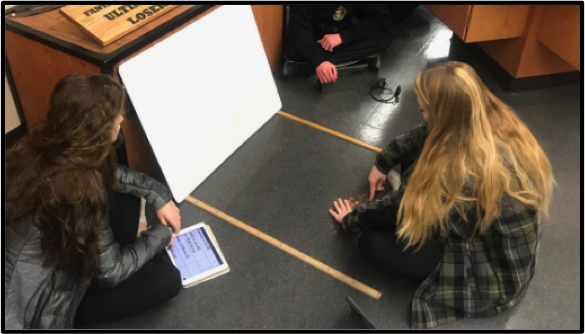 students shooting pennies and recording data